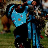 An Idigenous person performs a dance.